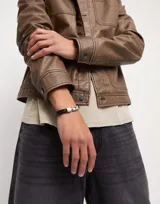 Pulsera de cuero trenzado color negro con cierre de acero plateado.