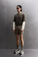 Shorts de running confeccionados en tejido técnico ligero y elástico, con forro interior. Presentan cintura elástica ajustable con cordón interior, aberturas laterales en el bajo, bolsillo lateral multifunción y bolsillo trasero con cierre de cremallera.