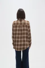 Camisa de algodón con estampado de cuadros en tonos marrones y blancos, de corte holgado, manga larga y cierre frontal con botones.