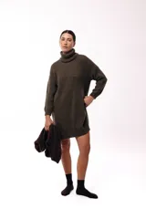 Vestido de punto color beige, de corte holgado y diseño oversized, con cuello alto tipo polera y mangas largas.