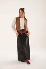 Chaleco color café de tejido sintético con escote en V y cierre frontal con botones forrados.