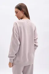 Buzo oversize color beige con cuello redondo y estampado frontal de flores y la inscripción "LES JARDINS 63".