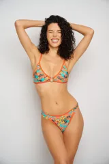 Corpiño de bikini con estampado de hojas en tonos azules y violetas, con aro metálico en el centro del busto y tirantes finos regulables que se cruzan en la espalda.