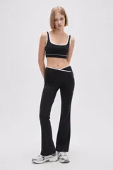 Top deportivo de poliamida color negro, con escote cuadrado y ribetes blancos en los bordes. Diseño ajustado al cuerpo con elástico en la base.