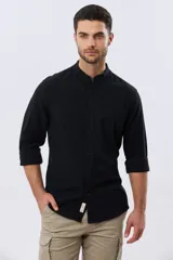 Camisa de lino y algodón color beige, de manga larga, con cuello mao y cierre frontal con botones. Presenta un pequeño bordado al tono en el pecho.