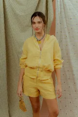 Campera tipo bomber de lino color amarillo, con cierre frontal metálico y mangas largas con puños elásticos.