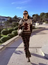 Sweater de punto con diseño color block en tonos marrón y beige, con detalle central de aplique de cuero con contorno bordado a mano.