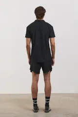 Chomba deportiva de manga corta, color negro, con cuello polo y cierre frontal de tres botones. Confeccionada en tejido técnico ultra liviano, fresco y respirable con alta elasticidad.