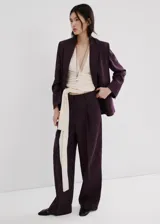 Pantalón de lino estilo sastrero, tiro bajo y diseño de pernera recta con trabillas en la cintura. Cuenta con bolsillos laterales y cierre oculto con botón, gancho y cremallera.