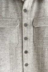 Camisa estilo leñadora marrón con diseño de espiga, cuello clásico, abrochadura frontal a la vista, bolsillos plaqué con tapa en el pecho, mangas largas con puño y botón.