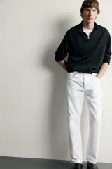 Jeans regular fit de corte recto y tiro medio, confeccionados en denim de algodón blanco con diseño de cinco bolsillos y cierre frontal con cremallera y botón.