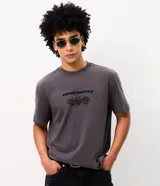 Remera gris oscuro de algodón, con cuello redondo y mangas cortas. Presenta un estampado frontal localizado con la inscripción "Avenged Sevenfold" y una calavera con alas.
