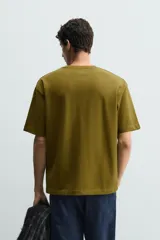 Remera de corte relaxed fit confeccionada en tejido de algodón con textura irregular, cuello redondo y manga corta.
