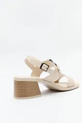 Sandalias de cuero color marrón con tacón cuadrado y hebilla lateral.