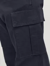 Pantalón cargo azul marino de corte relajado, con bolsillos traseros, frontales y laterales. Tiene cierre de gancho y cremallera, tiro medio y cordones en los dobladillos.