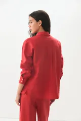 Camisa de lino y algodón color rojo, con cuello clásico, cierre frontal de botones y mangas largas con puños.