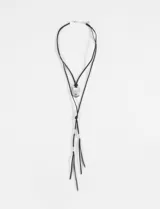 Collar de doble cordón negro con dije central ovalado plateado y terminaciones con cuentas metálicas en los extremos.