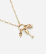 Collar corto de cadena eslabonada en tono dorado con un aro central del que cuelgan tres dijes: una porción de pizza, un helado y una copa, todos decorados con pequeñas piedras de colores.