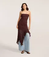 Vestido midi strapless de encaje floral bordó, con corte ajustado hasta la cadera y bajo asimétrico decorado con volados.