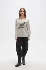 Sweater de tejido de punto color beige con estampado jacquard de leopardo en color negro. Presenta cuello redondo amplio y puños y ruedo acanalados.