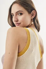 Top tejido color crema con rayas verticales y ribete amarillo en el escote asimétrico.