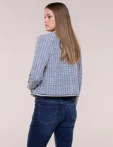 Chaqueta de tweed azul con tejido estructurado, escote redondo, bolsillos simulados con pasamanería y botones decorativos en las mangas.