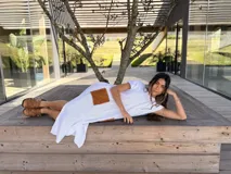 Vestido midi de punto color blanco, confeccionado en algodón, con mangas cortas, aberturas laterales y bolsillos aplicados de cuero marrón con detalles bordados a mano.