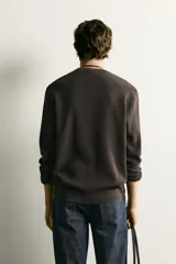 Sweater de punto color beige con textura tipo waffle, cuello redondo y mangas largas con acabado en rib.