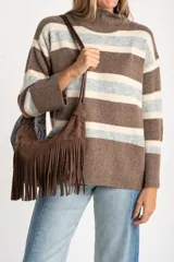 Polera de tejido de punto con diseño a rayas horizontales en tonos marrón, beige y gris. Presenta cuello alto, mangas largas con puños anchos y un corte holgado.