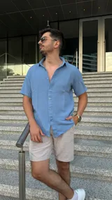 Camisa celeste de manga corta con cuello clásico y cierre frontal con botones.