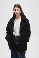 Tapado de lana con diseño a cuadros en tonos marrones y beige, de corte holgado, con cuello de solapa y cierre frontal con botones.