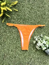 Conjunto de bikini naranja, con corpiño triangular fijo y bombacha colaless regulable.