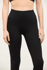 Calza deportiva de tiro alto con diseño sin costuras en el frente, confeccionada en tejido suave y elastizado de compresión media.