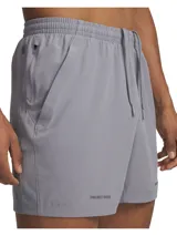 Short deportivo gris de Under Armour, modelo Project Rock Ultimate, confeccionado en tejido elástico con paneles de malla transpirable y bolsillos laterales.