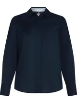 Camisa de manga larga color azul marino, confeccionada en tejido de popelina de algodón BCI. Presenta cuello clásico, cierre frontal de botones, bolsillo de parche en el pecho y puños abotonados.