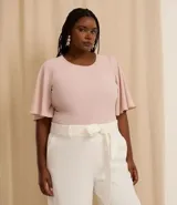 Blusa de crepé color rosa pálido, con cuello redondo, mangas cortas con volados, lazo en la cintura y botón en la espalda.