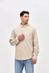 Camisa de corte regular fit confeccionada en algodón, con cuello solapa clásico, cierre frontal con botones y dos bolsillos frontales en el pecho.