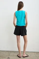 Short color crudo de tiro bajo, con pretina elástica y detalles laterales en marrón y verde militar.