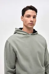 Canguro de felpa con friza, de calce clásico y diseño con cortes en el cuerpo. Presenta capucha con interior en contraste y bolsillos laterales con puños.