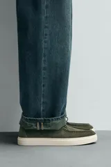 Zapato casual de hombre, color beige claro, con capellada de serraje (gamuza) y cordones finos. Presenta un detalle de bordón en el empeine y suela gruesa de goma a contraste en color crema.