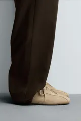 Zapatilla de estilo retro color beige, con cordones y parte superior de piel serraje. Cordonera oculta y suela ultrafina.