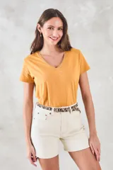 Remera de algodón color mostaza, de manga corta y escote en V con detalle metalizado.