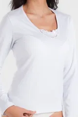Camiseta interior blanca de manga larga con escote en U y detalle de puntilla en el cuello.