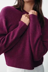 Jersey de punto con cuello redondo y manga larga, confeccionado en un suave tejido color bordó.