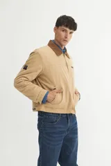 Campera tipo chaqueta color beige, con cuello marrón de pana y cierre frontal con cremallera.