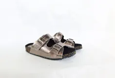 Sandalias de cuero color peltre con doble tira ancha ajustable con hebillas metálicas. Suela de corcho y base de goma.