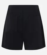 Short pollera negro de crepé con diseño cruzado, bolsillos traseros y pinzas.