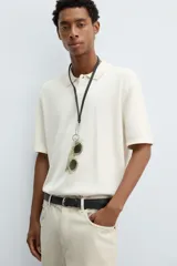 Polo de punto de corte regular fit, confeccionado en una mezcla de algodón y lyocell. Presenta cuello de solapa con cierre frontal de botones, manga corta y acabados en rib en puños y bajo.