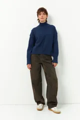 Polera de tejido de punto color bordó, con cuello alto, manga larga y costura vertical central en el frente.