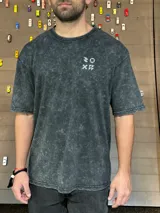 Remera gris con efecto gastado, corte oversize, mangas cortas y estampado en la espalda con el texto "SUPPLY GOODS DESIGNED IN PUNTA DEL ESTE".